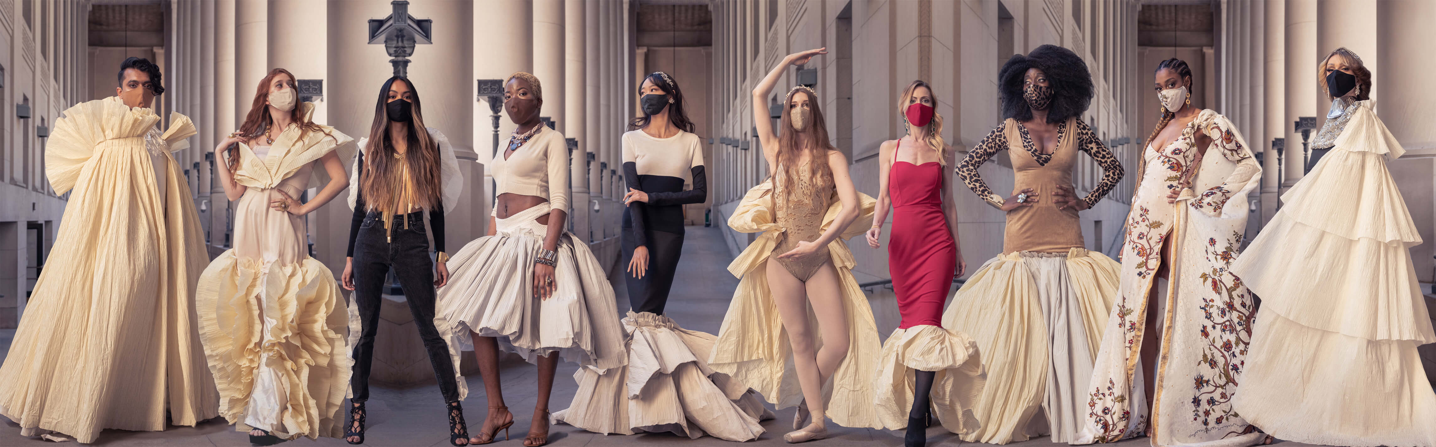 Group image of striking models featuring the Chrysalis Collection made from repurposed clothes and pleated paper ruffles, set against the backdrop of a grand neoclassical colonnade.